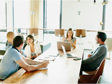 Group of people sitting at a conference table, working together